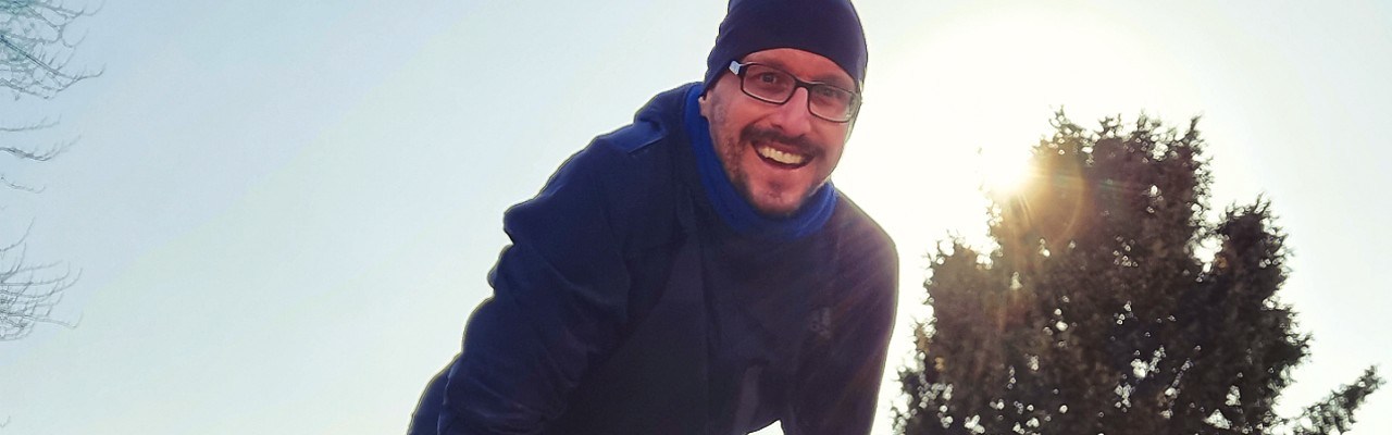 Stefan Kübler nach dem Laufen vor blauem Himmel und Sonne.