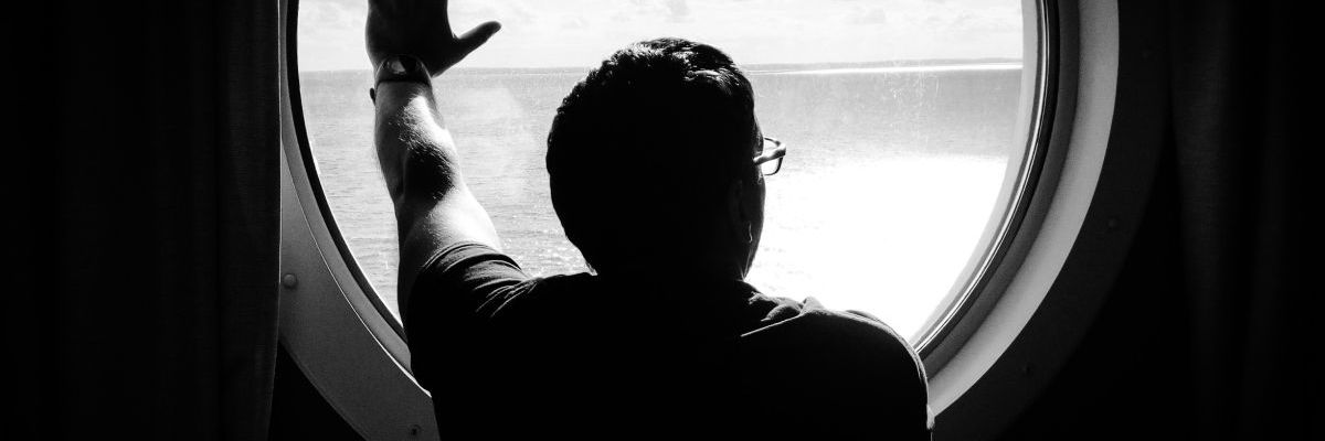 Stefan Kübler in der Kabine eines Schiffs mit der Hand am Fenster und dem Blick hinaus aufs Meer.