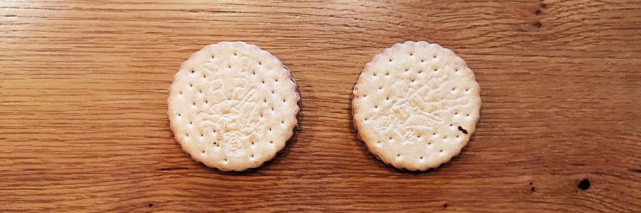 Draufsicht auf zwei Kekse auf einem Esstisch.