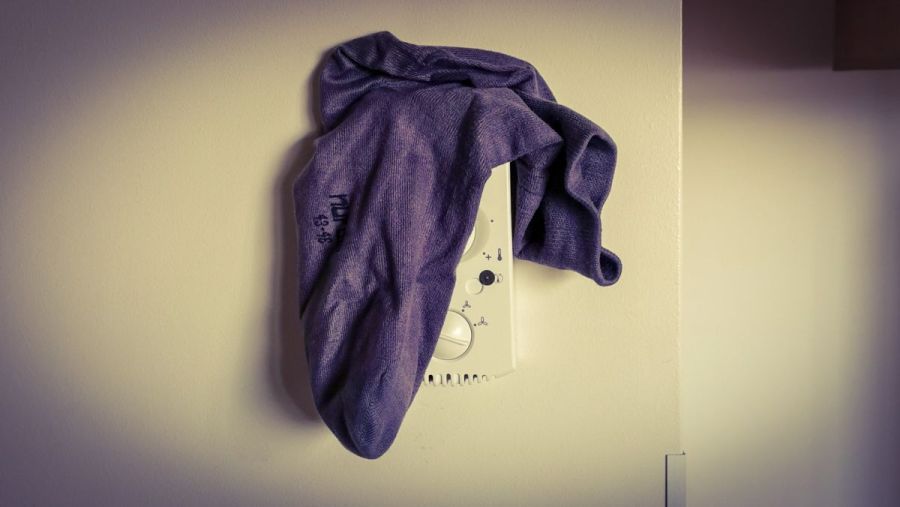 Eine Socke hängt über der Steuerung einer Klimaanlage an der Wand.