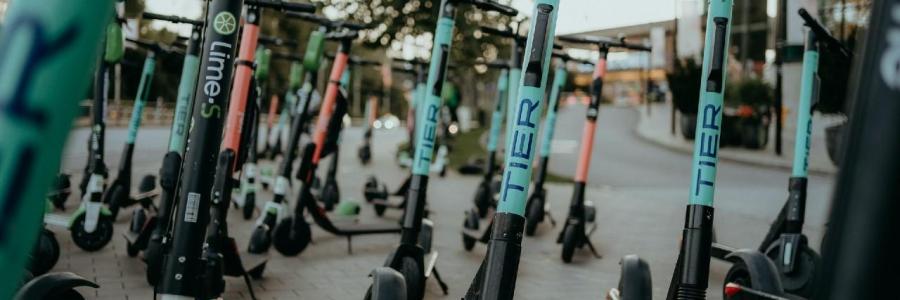 Viele verschiedene Elektroroller am Straßenrand.