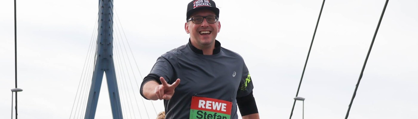 Stefan Kübler mit einem Pfeiler der Köhlbrandbrücke im Hintergrund.