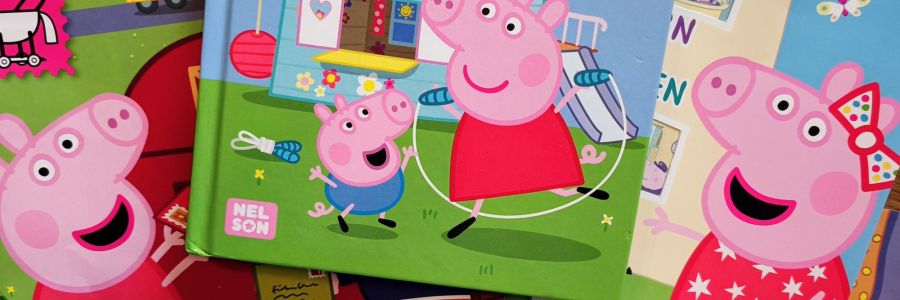 Mehrere Bücher und Hefte von Peppa Wutz neben- und übereinander.