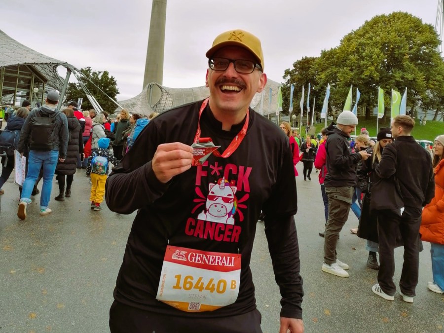 Stefan Kübler mit Medaille nach dem Halbmarathon in München.